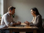 Two adults having a serious discussion at a table